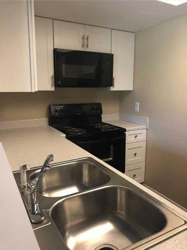 1042 Mollie Ln Unit 81042, Melbourne, FL 32935 - kitchen featuring black appliances, white cabinetry, and light countertops