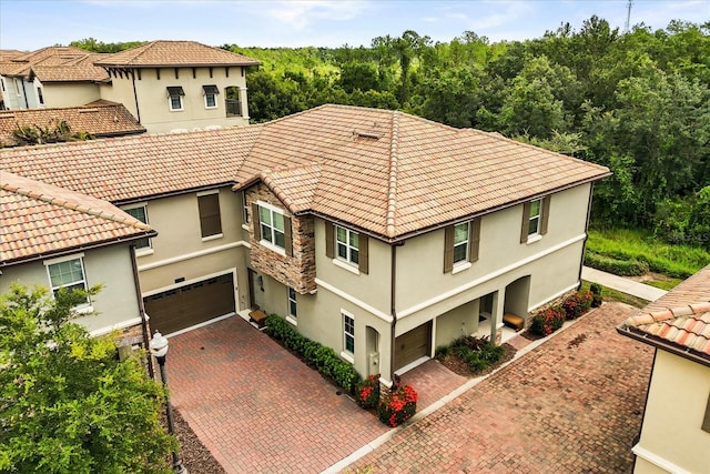 1351 Shinnecock Hills Dr, Davenport, FL 33896 - view of property exterior featuring a garage, decorative driveway, stucco siding, and a tiled roof