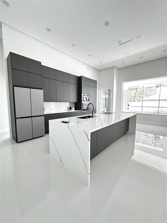 9 Edison Ln, Palm Coast, FL 32164 - kitchen with freestanding refrigerator, modern cabinets, light tile patterned floors, a large island with sink, and recessed lighting