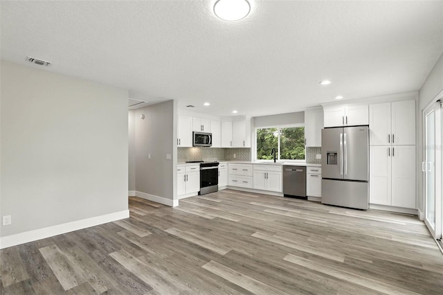 1850 N St, Longwood, FL 32750 - kitchen featuring stainless steel appliances, backsplash, recessed lighting, light countertops, and white cabinetry