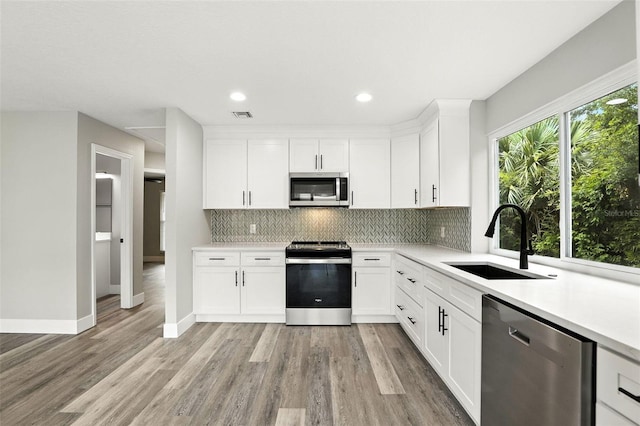 1850 N St, Longwood, FL 32750 - kitchen featuring stainless steel appliances, tasteful backsplash, light wood-type flooring, light countertops, and recessed lighting