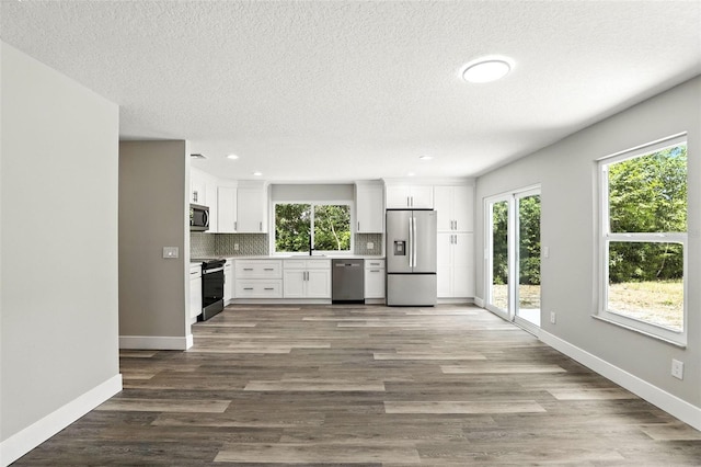 1850 N St, Longwood, FL 32750 - kitchen with stainless steel appliances, decorative backsplash, white cabinetry, light countertops, and a textured ceiling