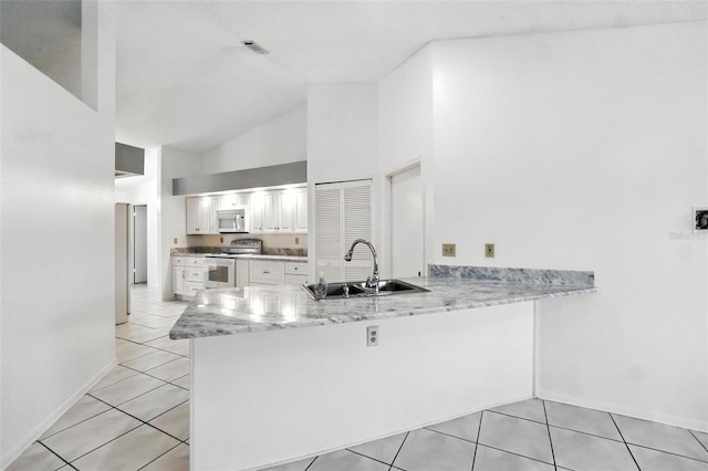22 Bradford Ct, Kissimmee, FL 34758 - kitchen with white appliances, a peninsula, white cabinetry, high vaulted ceiling, and light tile patterned flooring