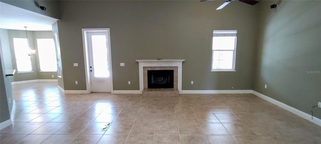 5595 Schefflera, Grant, FL 32949 - unfurnished living room featuring ceiling fan, light tile patterned floors, a fireplace, and a chandelier