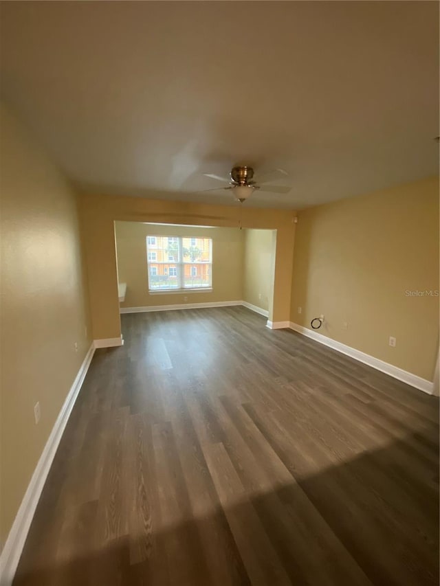 spare room with a ceiling fan and dark wood-style flooring