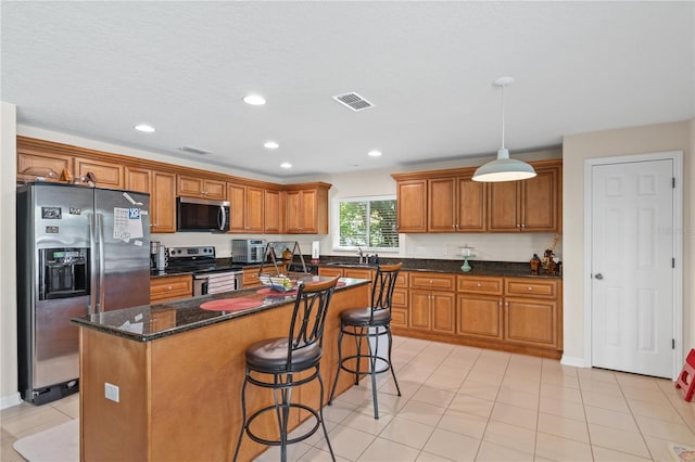 2613 Breezy Meadow Rd, Apopka, FL 32712 - kitchen featuring stainless steel appliances, brown cabinetry, a center island, a breakfast bar area, and recessed lighting