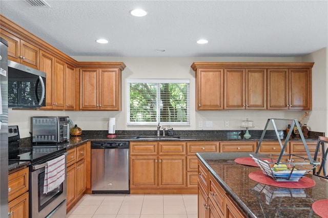 2613 Breezy Meadow Rd, Apopka, FL 32712 - kitchen with appliances with stainless steel finishes, brown cabinetry, dark stone countertops, and recessed lighting