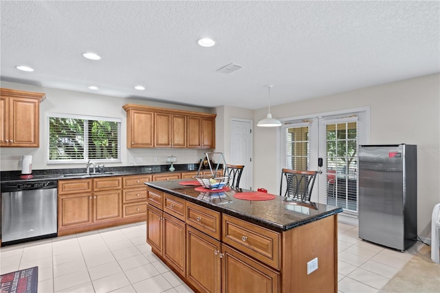 2613 Breezy Meadow Rd, Apopka, FL 32712 - kitchen with appliances with stainless steel finishes, french doors, brown cabinetry, a textured ceiling, and a kitchen island