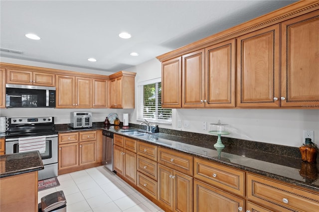 2613 Breezy Meadow Rd, Apopka, FL 32712 - kitchen featuring stainless steel appliances, dark stone countertops, recessed lighting, brown cabinetry, and light tile patterned floors