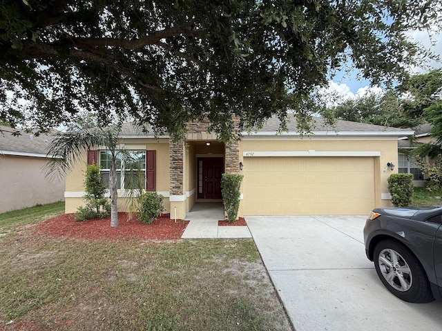 4792 Summerfield Cir, Winter Haven, FL 33881 - view of front of property featuring an attached garage, stucco siding, concrete driveway, and stone siding