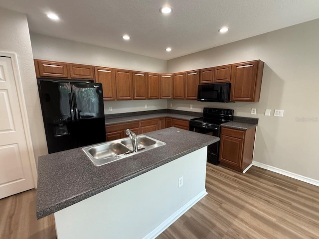 4792 Summerfield Cir, Winter Haven, FL 33881 - kitchen with black appliances, dark countertops, light wood-style flooring, recessed lighting, and brown cabinetry