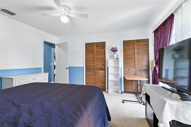 1515 Colonist Ct, Orlando, FL 32818 - bedroom featuring multiple closets, light colored carpet, ceiling fan, and a textured ceiling