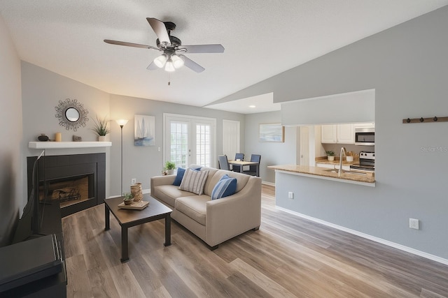 2550 Alafaya Trl Unit 9303, Orlando, FL 32826 - living area featuring lofted ceiling, a ceiling fan, light wood finished floors, and a fireplace