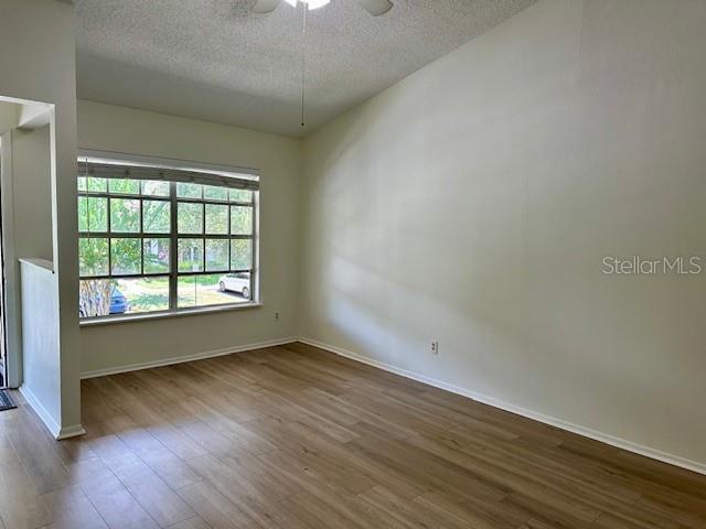125 Reserve Cir Unit 205, Oviedo, FL 32765 - unfurnished room featuring a textured ceiling, wood finished floors, and ceiling fan