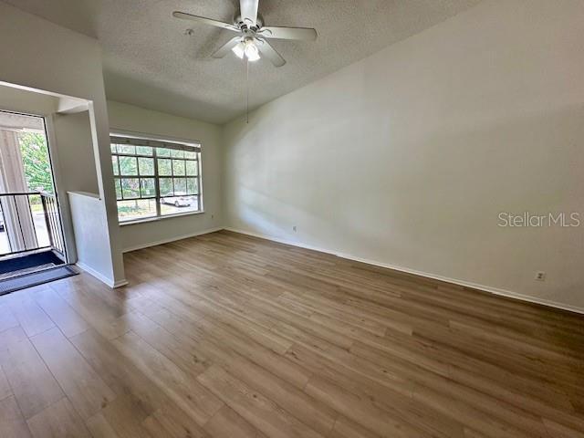 125 Reserve Cir Unit 205, Oviedo, FL 32765 - unfurnished room featuring a textured ceiling, wood finished floors, ceiling fan, and lofted ceiling