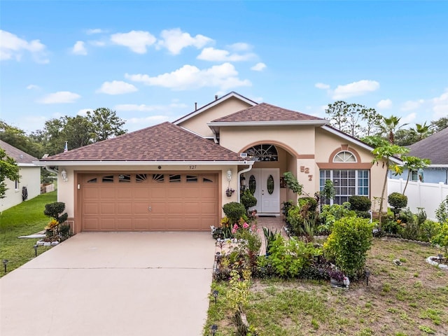 527 Durango Loop St, Davenport, FL 33897 - view of front facade with stucco siding, an attached garage, concrete driveway, and roof with shingles