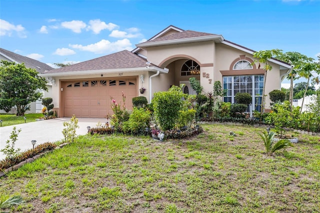 527 Durango Loop St, Davenport, FL 33897 - view of front of property with stucco siding, an attached garage, driveway, and a shingled roof