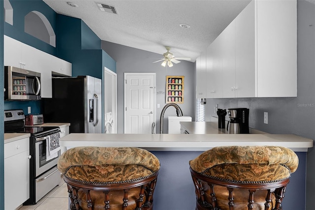 527 Durango Loop St, Davenport, FL 33897 - kitchen with stainless steel appliances, ceiling fan, light countertops, white cabinets, and a textured ceiling