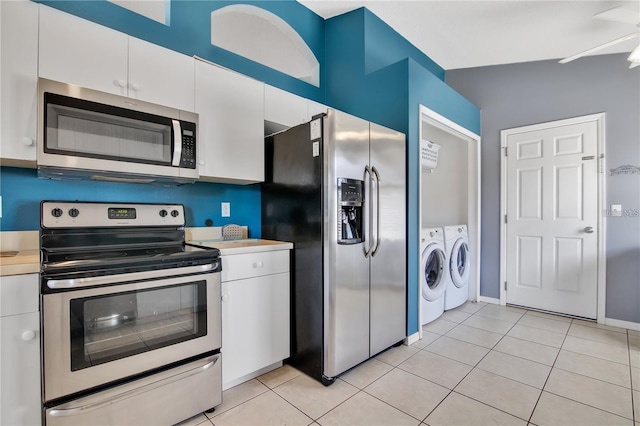 527 Durango Loop St, Davenport, FL 33897 - kitchen with appliances with stainless steel finishes, independent washer and dryer, light countertops, white cabinetry, and light tile patterned flooring