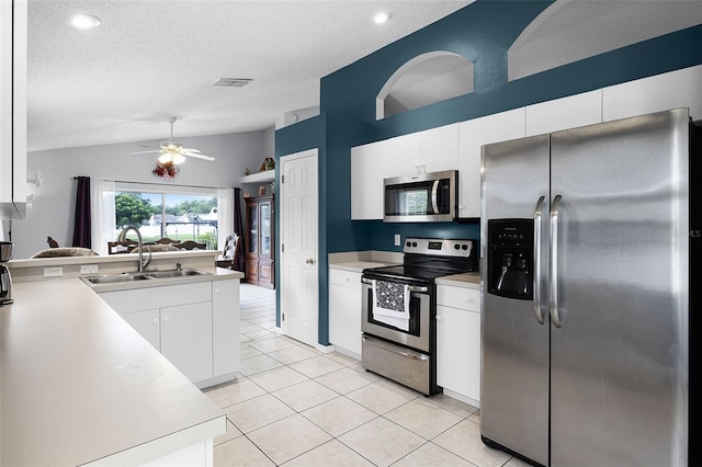 527 Durango Loop St, Davenport, FL 33897 - kitchen featuring stainless steel appliances, vaulted ceiling, a peninsula, light tile patterned flooring, and a ceiling fan