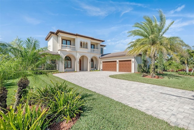 14315 80th Ave, Sebastian, FL 32958 - mediterranean / spanish home featuring a balcony, a garage, a tiled roof, and decorative driveway