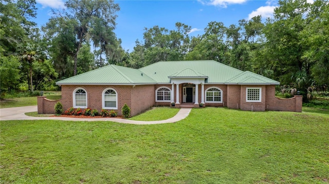 1908 S Farm Rd, Deland, FL 32720 - view of front of home with a front lawn, a metal roof, and brick siding