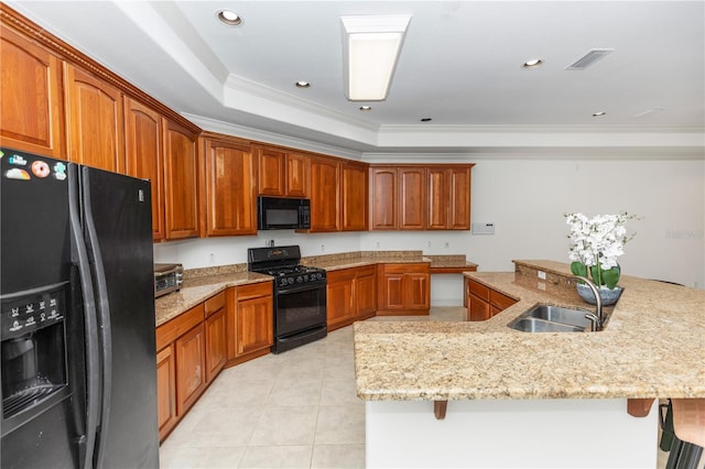 1908 S Farm Rd, Deland, FL 32720 - kitchen with black appliances, a kitchen breakfast bar, ornamental molding, light stone counters, and light tile patterned floors