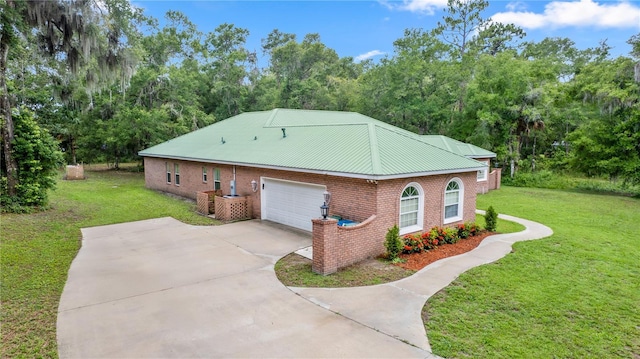 1908 S Farm Rd, Deland, FL 32720 - view of side of property with brick siding, a lawn, driveway, and a metal roof
