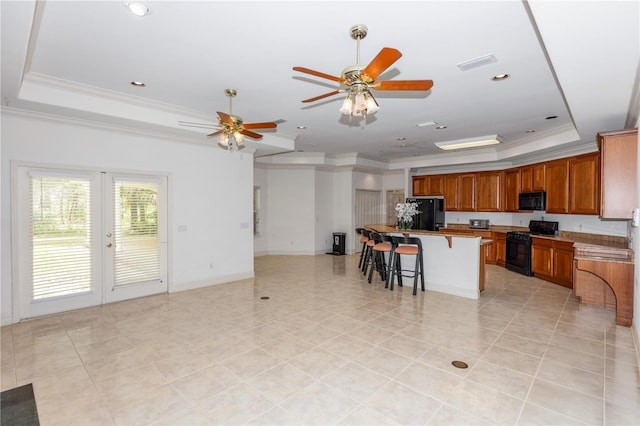 1908 S Farm Rd, Deland, FL 32720 - kitchen with a raised ceiling, black appliances, crown molding, a kitchen bar, and brown cabinets