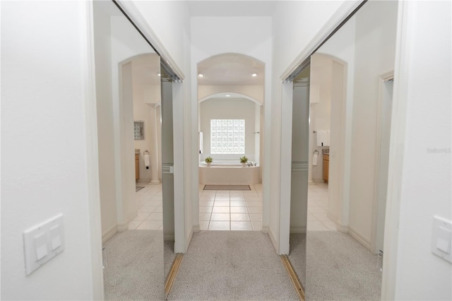 1908 S Farm Rd, Deland, FL 32720 - hallway with arched walkways, light tile patterned floors, and light colored carpet