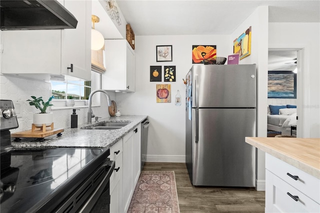 1100 E Caroline St Unit 204, Tavares, FL 32778 - kitchen featuring appliances with stainless steel finishes, extractor fan, white cabinetry, dark wood-type flooring, and light stone countertops
