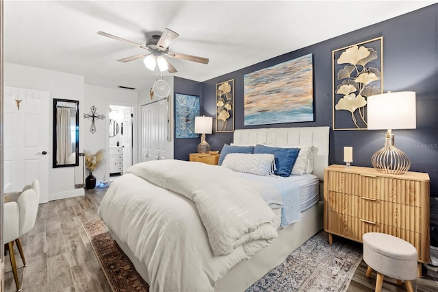 1100 E Caroline St Unit 204, Tavares, FL 32778 - bedroom featuring wood finished floors, ensuite bathroom, a ceiling fan, and a closet