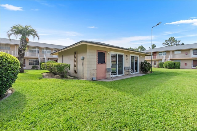 1100 E Caroline St Unit 204, Tavares, FL 32778 - rear view of property featuring concrete block siding and a yard