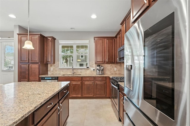 1110 Pine Falls Ln, Ocoee, FL 34761 - kitchen with appliances with stainless steel finishes, backsplash, light stone countertops, decorative light fixtures, and recessed lighting