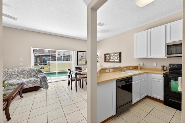 4558 Baleno Ln, Kissimmee, FL 34746 - kitchen featuring black appliances, light countertops, white cabinetry, light tile patterned floors, and a textured ceiling