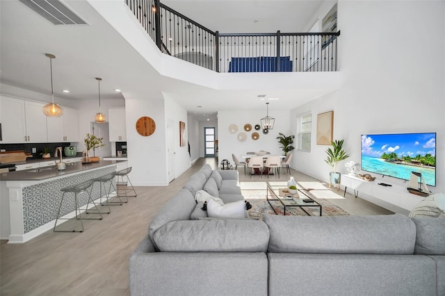 9175 Sommerset Hills Dr, Davenport, FL 33896 - living room featuring plenty of natural light, light wood finished floors, a high ceiling, a chandelier, and recessed lighting