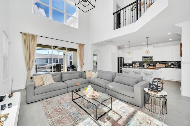 9175 Sommerset Hills Dr, Davenport, FL 33896 - living room with a high ceiling, arched walkways, and a chandelier