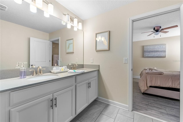 2907 Fable St, Kissimmee, FL 34746 - ensuite bathroom featuring double vanity, ceiling fan, a textured ceiling, and tile patterned floors