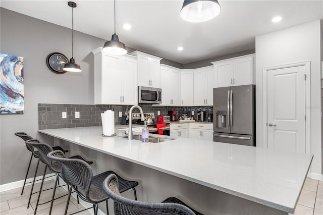 2907 Fable St, Kissimmee, FL 34746 - kitchen with stainless steel appliances, a peninsula, backsplash, light countertops, and recessed lighting