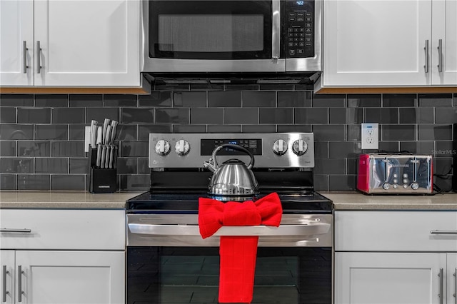 2907 Fable St, Kissimmee, FL 34746 - kitchen view of appliances with stainless steel finishes, white cabinetry, tasteful backsplash, and light countertops