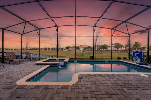 2907 Fable St, Kissimmee, FL 34746 - pool at dusk featuring a patio area, a pool with connected hot tub, a lanai, and a water view