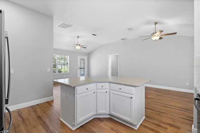 449 Timmonsville Way, The Villages, FL 32162 - kitchen featuring a ceiling fan, vaulted ceiling, stainless steel refrigerator, wood finished floors, and white cabinetry