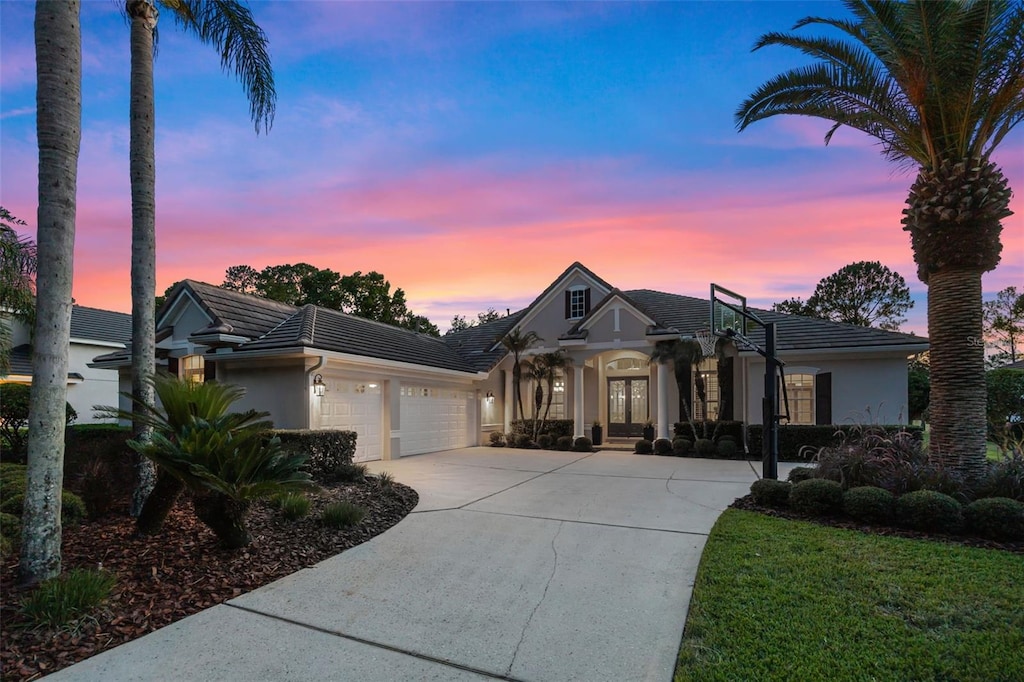 3267 Regal Crest Dr, Longwood, FL 32779 - view of front of property with stucco siding, an attached garage, a tile roof, and driveway