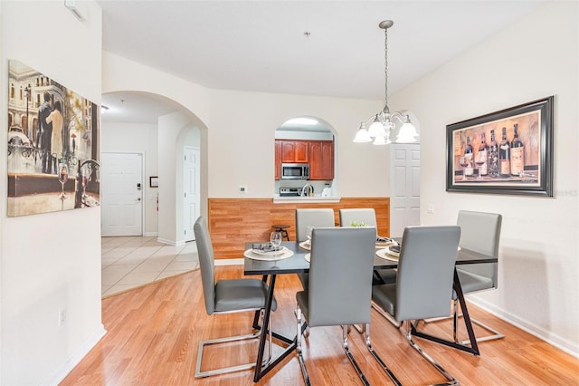 4114 Breakview Dr Unit 110, Orlando, FL 32819 - dining space featuring arched walkways, light wood-style floors, and a chandelier