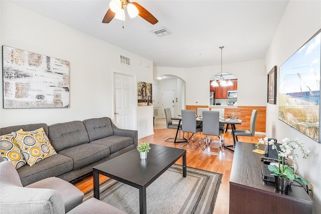 4114 Breakview Dr Unit 110, Orlando, FL 32819 - living room featuring arched walkways, ceiling fan, light wood-style floors, and a chandelier