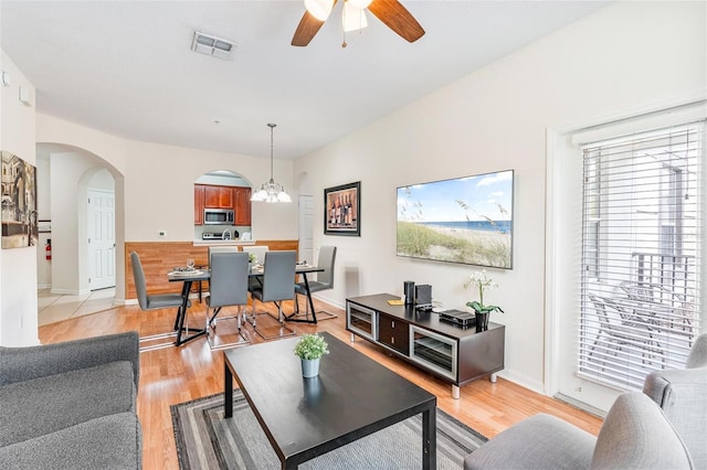 4114 Breakview Dr Unit 110, Orlando, FL 32819 - living room featuring light wood-type flooring, arched walkways, a ceiling fan, and a chandelier