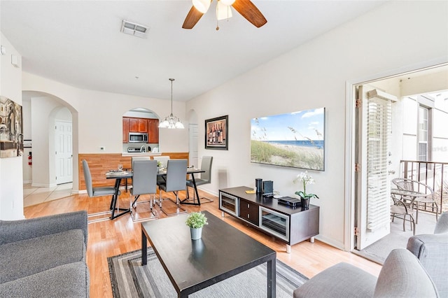 4114 Breakview Dr Unit 110, Orlando, FL 32819 - living room featuring arched walkways, light wood-style flooring, ceiling fan, and a chandelier
