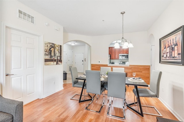 4114 Breakview Dr Unit 110, Orlando, FL 32819 - dining space with arched walkways, a chandelier, and light wood-type flooring