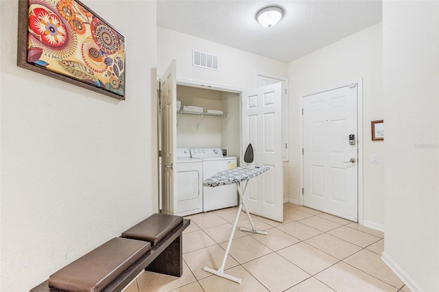 4114 Breakview Dr Unit 110, Orlando, FL 32819 - washroom featuring separate washer and dryer, light tile patterned floors, and a textured ceiling