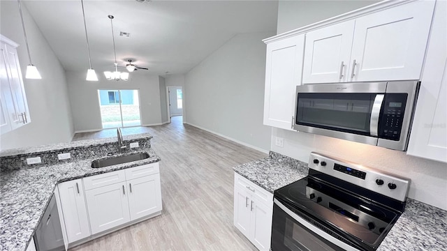 4413 Grass Ave, Sebring, FL 33875 - kitchen with stainless steel appliances, lofted ceiling, light wood-type flooring, light stone countertops, and white cabinetry
